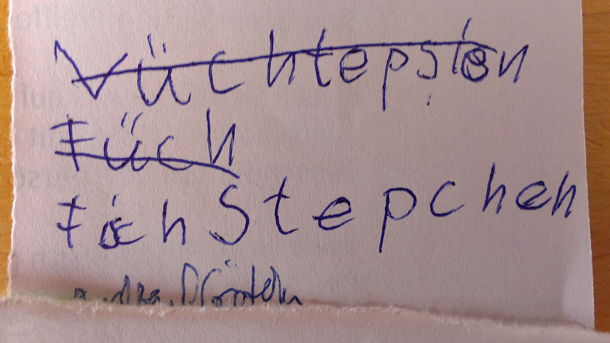 Einkaufszettel, auf dem jemand versucht hat, das Wort Fischstäbchen anständig zu schreiben